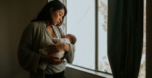 A mother holding her baby while on maternity leave