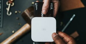 Person holding Visa card and card reader