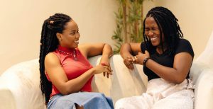 A woman talking to her mum while sitting on a white sofa