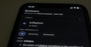 A close up of a phone with the definition for inflation searched on it