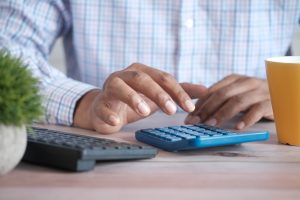 Close up of man's hand using calculator