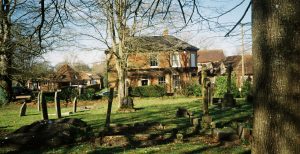 A graveyard with a house behind it