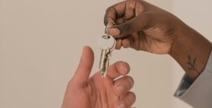 A person handing a key over to another person