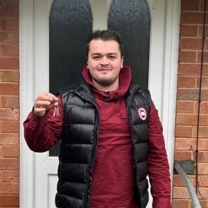 Jack Tucker - First-Time Buyer client of The Levels Financial standing outside of his new house while holding up the keys