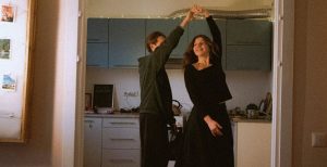 Two first-time buyers dancing in the kitchen after buying their first house with the help of a mortgage broker