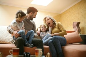 A couple with their two kids having fun in their new home after moving