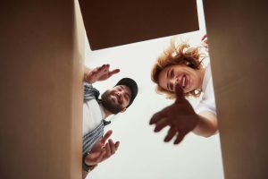 A young couple reaching into a box while moving home