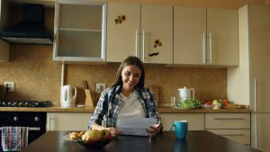 A woman looking over her documents for remortgaging while sitting in her kitchen