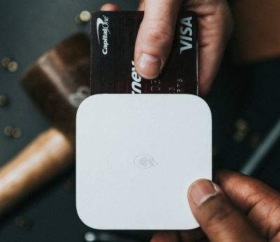 Person holding a Visa credit card and card reader