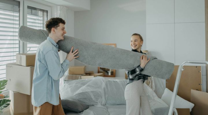 A couple moving a rug into their new home together