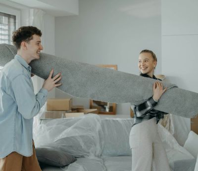 A couple moving a rug into their new home together