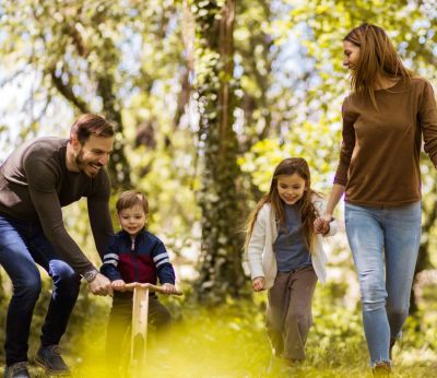 Parents playing with their children in the woods