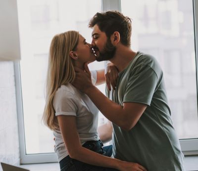 A young first time home buyer couple kissing