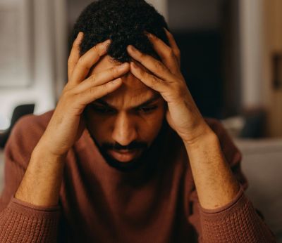 A man with his head in his hands looking frustrated