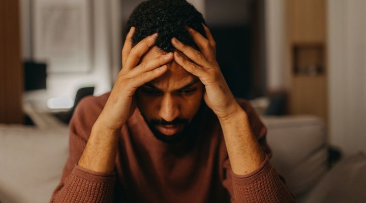 A man with his head in his hands looking frustrated