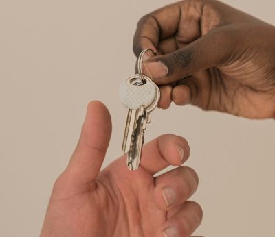 A person handing a key over to another person