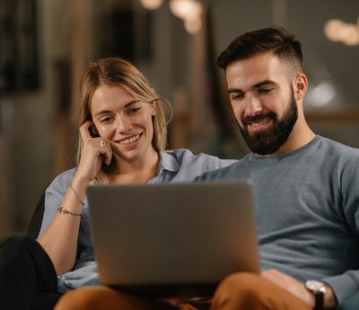 A young couple looking at their laptop while on a mortgage appointment
