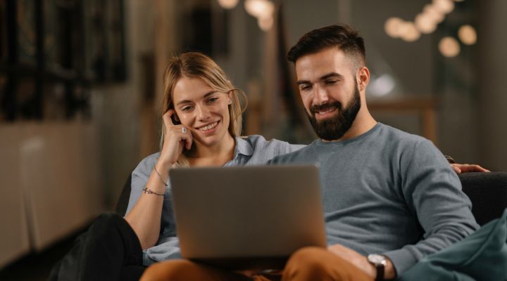 A young couple looking at their laptop while on a mortgage appointment