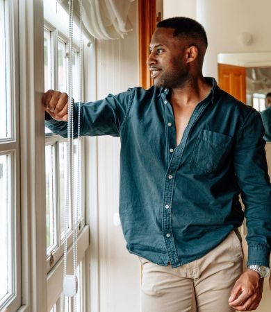 A man looking out of a window while viewing a house