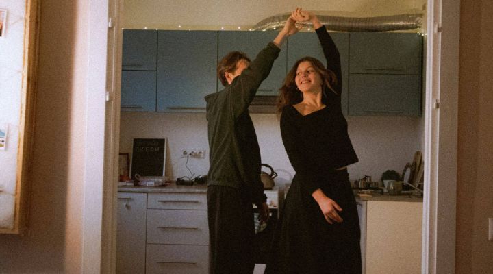 Two first-time buyers dancing in the kitchen after buying their first house with the help of a mortgage broker