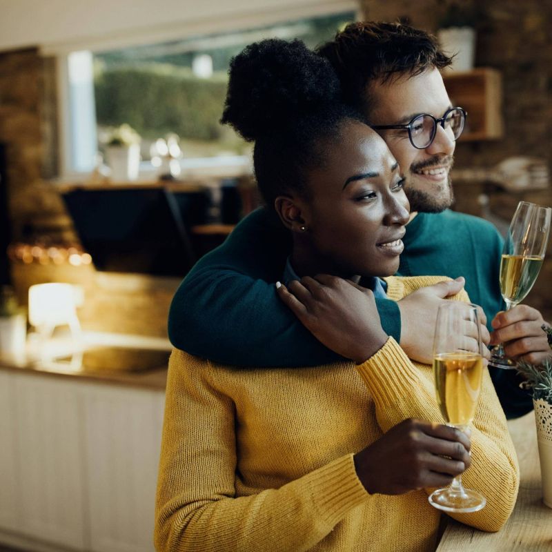 A couple drinking champagne in their new home after securing a mortgage with a mortgage advisor