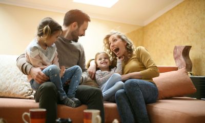 A couple with their two kids having fun in their new home after moving
