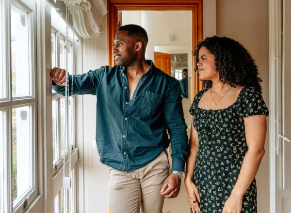 A couple looking out of the window while on a house viewing