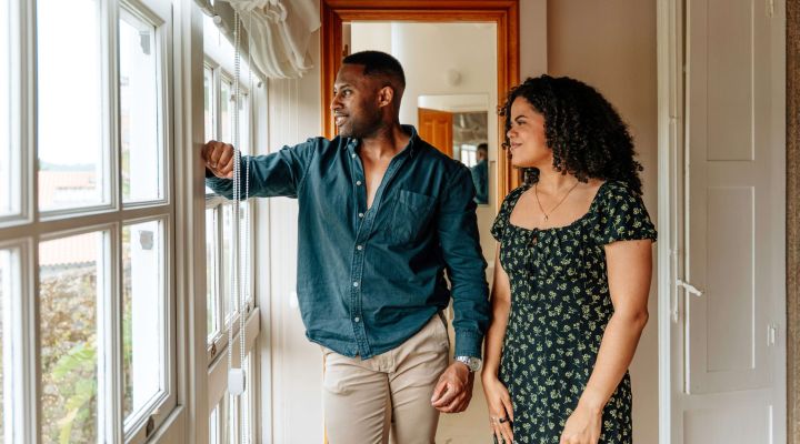 A couple looking out of the window while on a house viewing