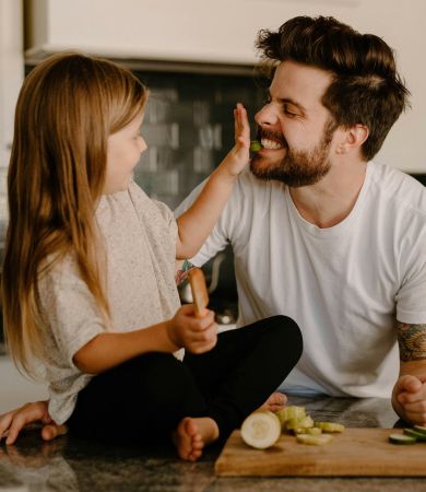 A man and a little girl sitting on the kitchen counter