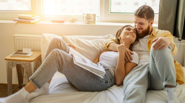 A young couple laying in bed together
