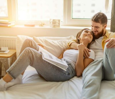 A young couple laying in bed together