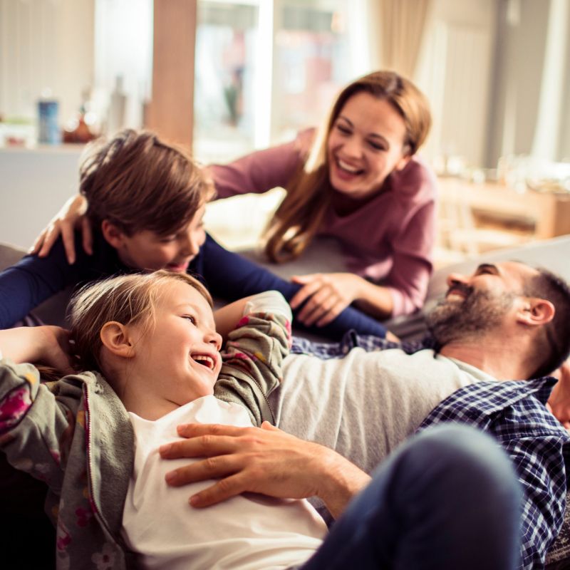 Happy young family relaxing on the couch together at home