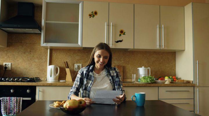 A woman looking over her documents for remortgaging while sitting in her kitchen